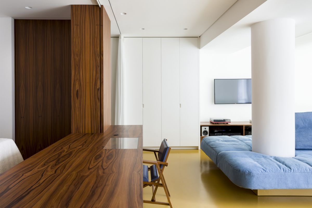 The apartment features yellow epoxy flooring which gives it a bold look while also visually connecting all the spaces